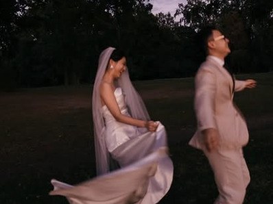 Filmstill: Braut wirbelt ihr Kleid in der Abenddämmerung